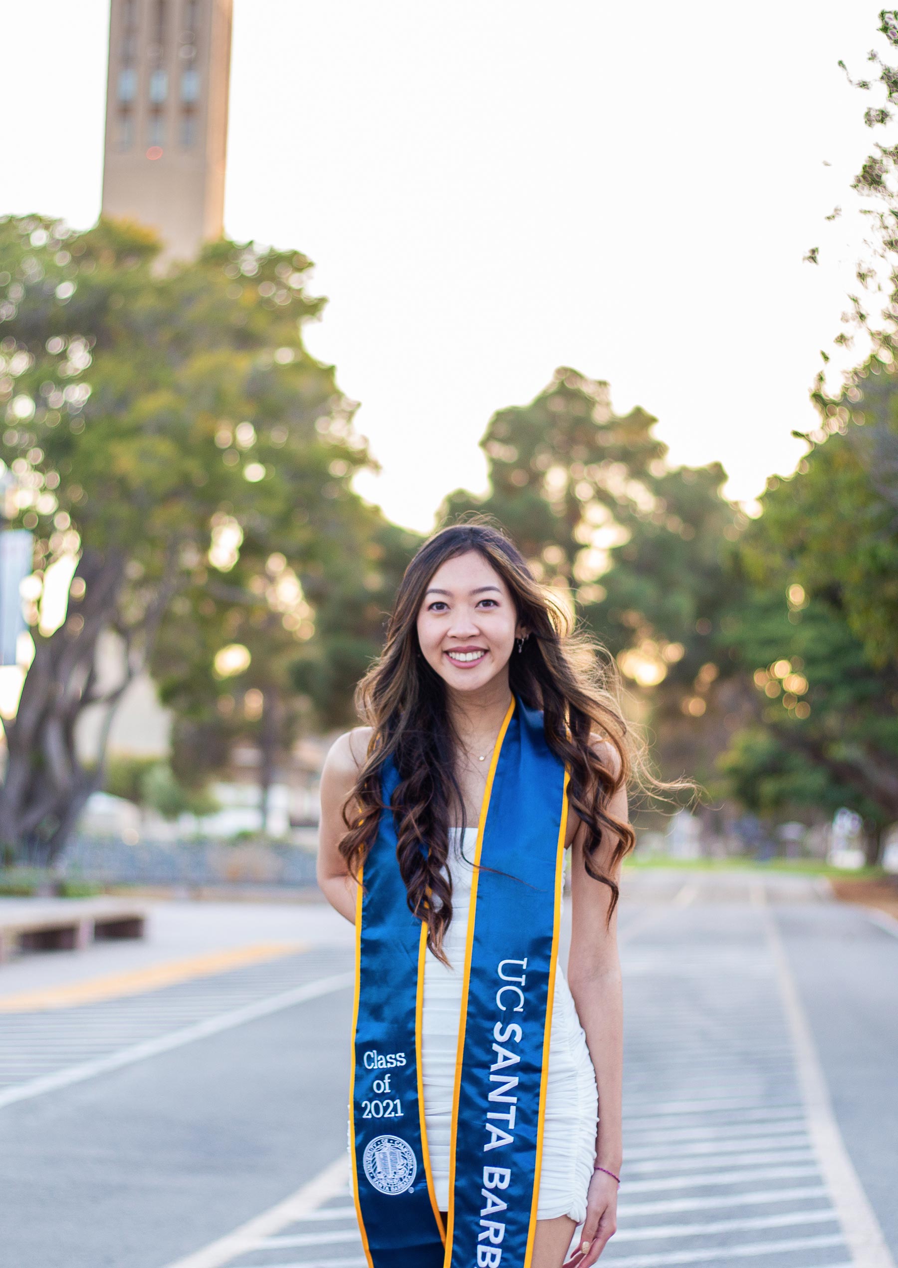 Chassidie Liu stands in an empty bike path with Storke Tower behind her in the distance.