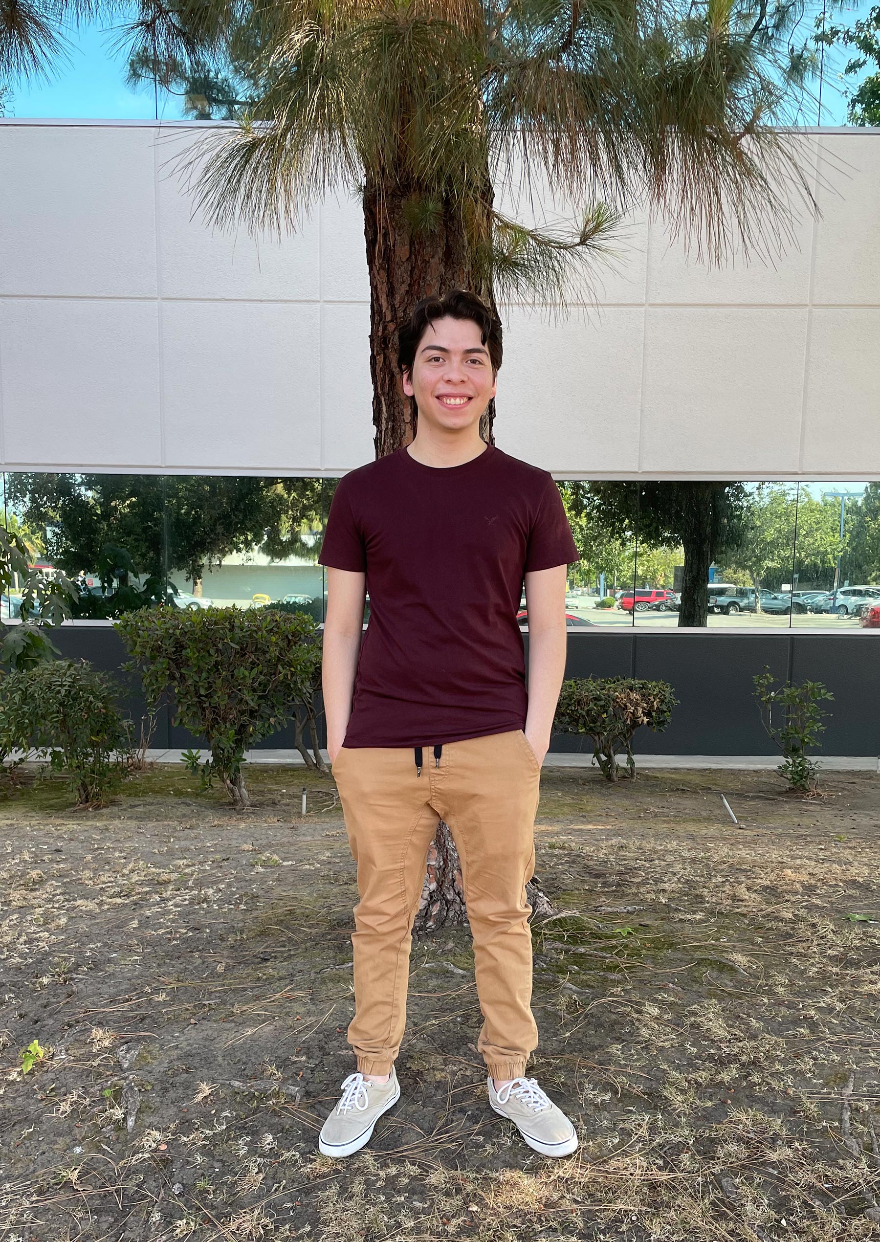 Jonathan Larach smiles while standing in front of a palm tree
