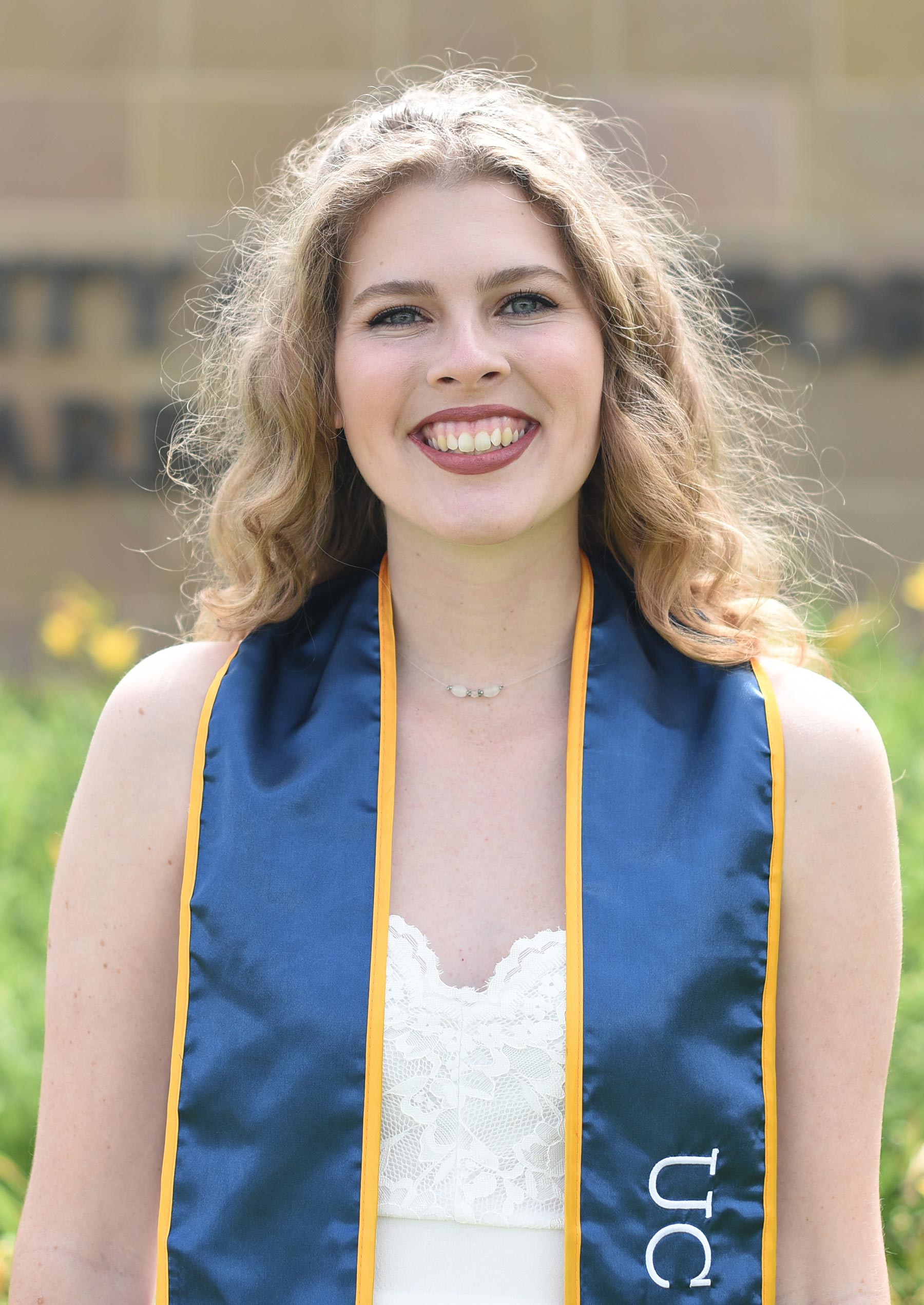 Justine Johnson-Yurchak wears a Class of 2021 stole in front of Henley Gate at UC Santa Barbara