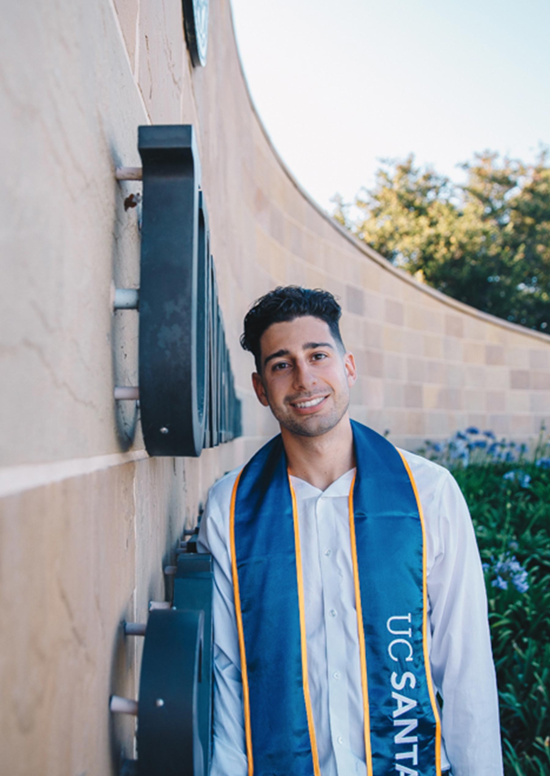 Rami Abulaban stands by Henley Gate wearing a Class of 2021 stole.