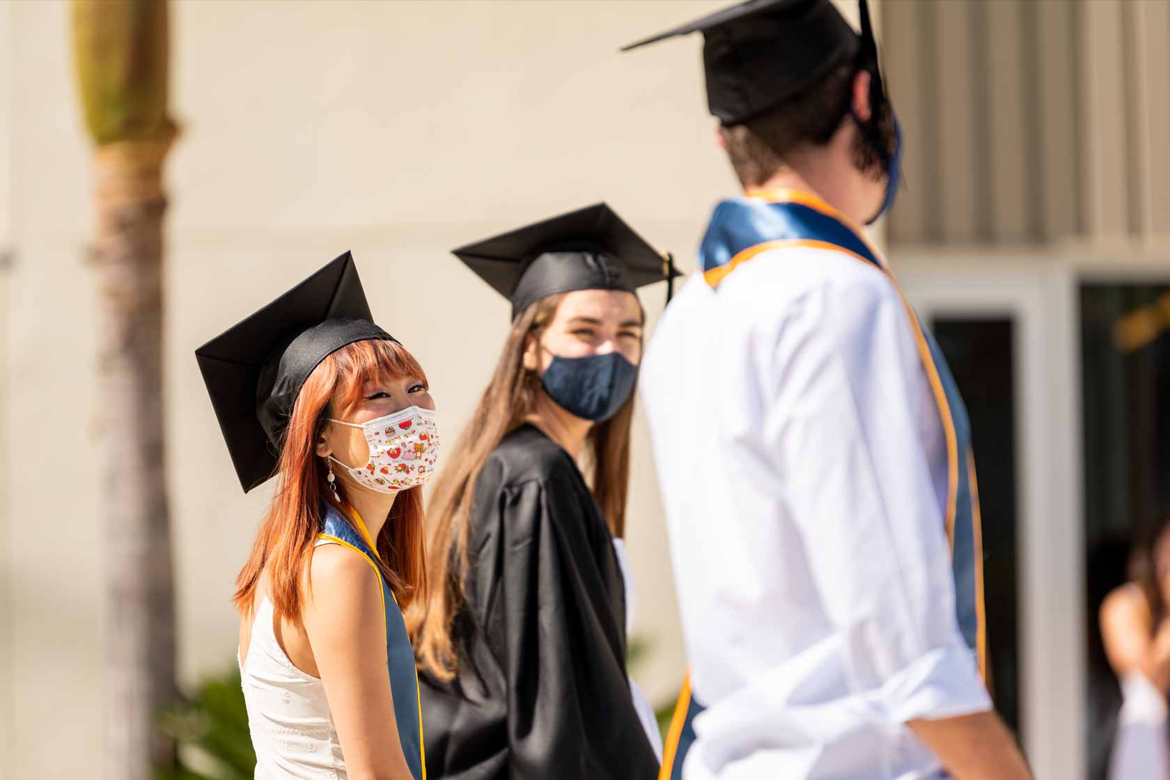 Graduates lined up smiling to each other