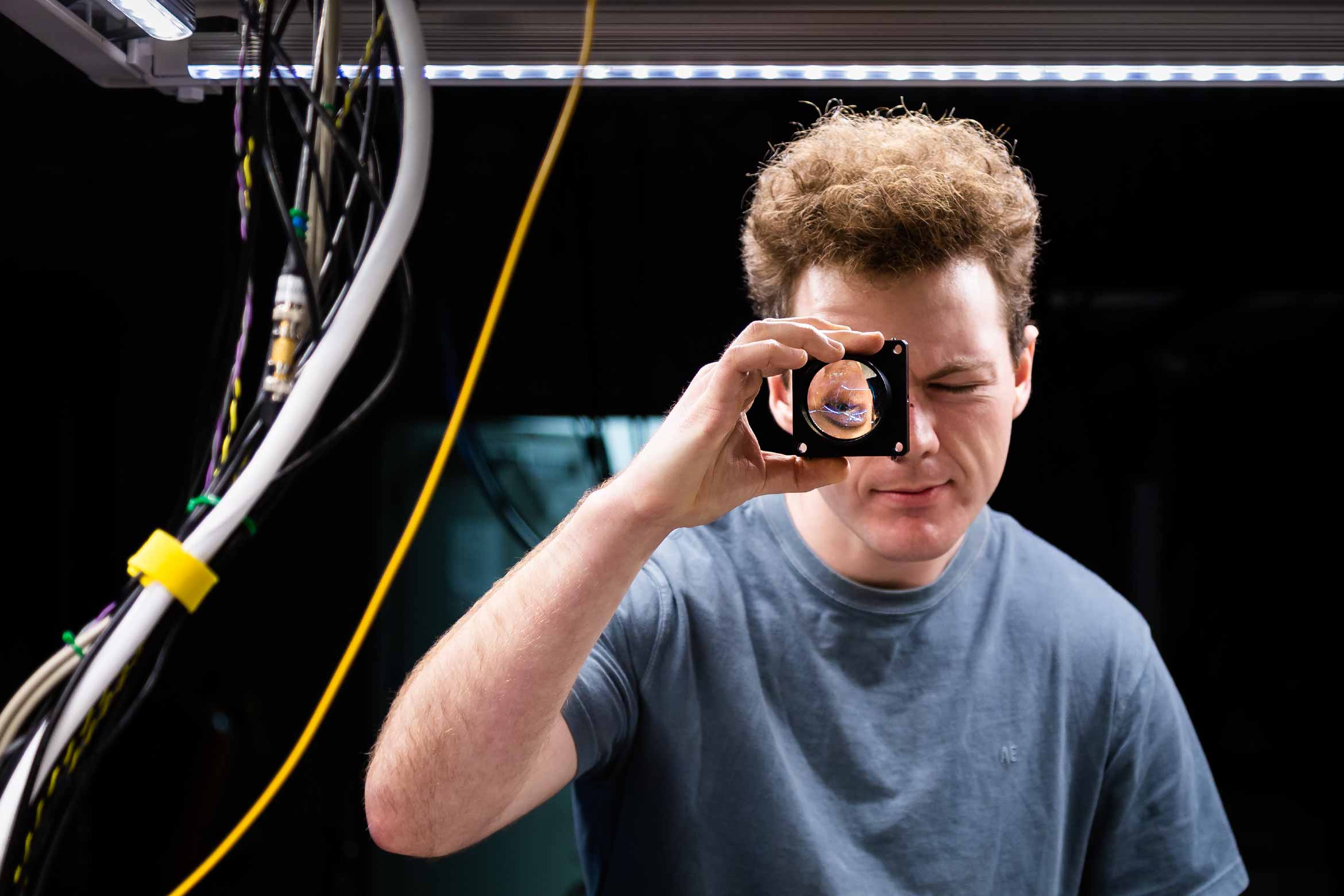 graduate-degrees-physics.jpg graduate student with lens