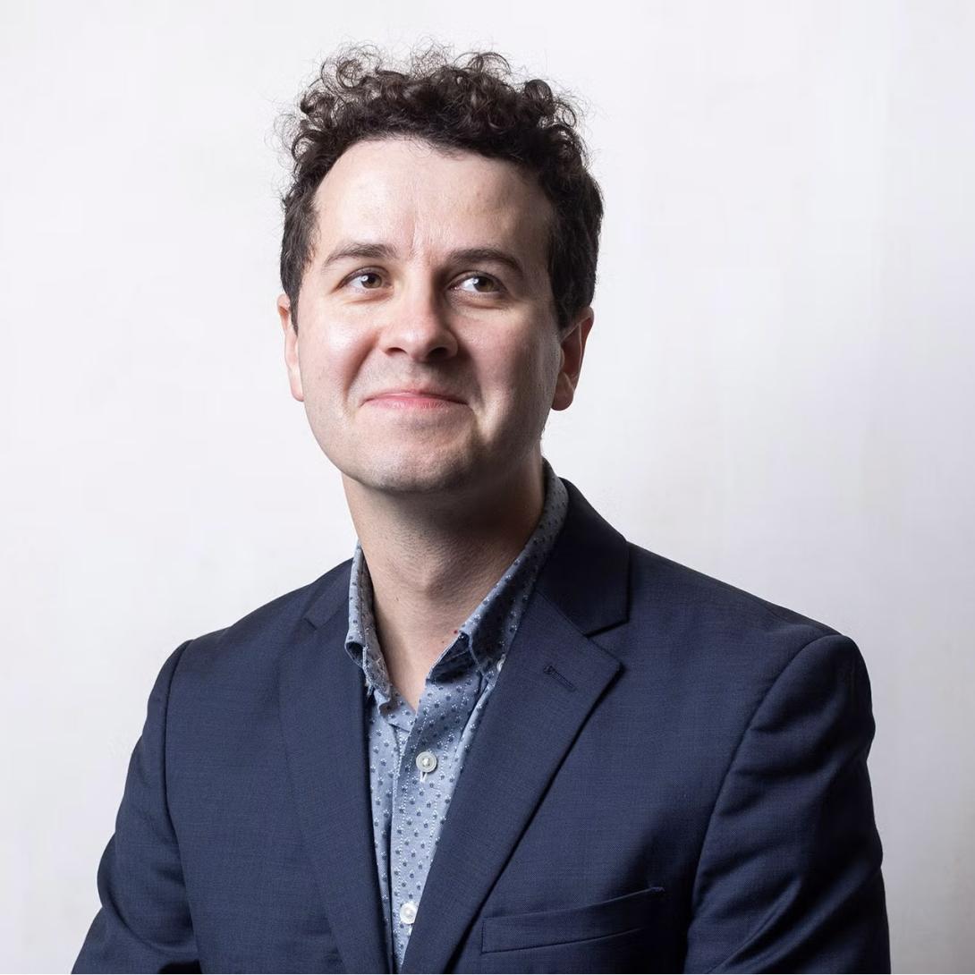 Vladimir Hamed-Troyansky wears a navy blazer and a blue collared shirt